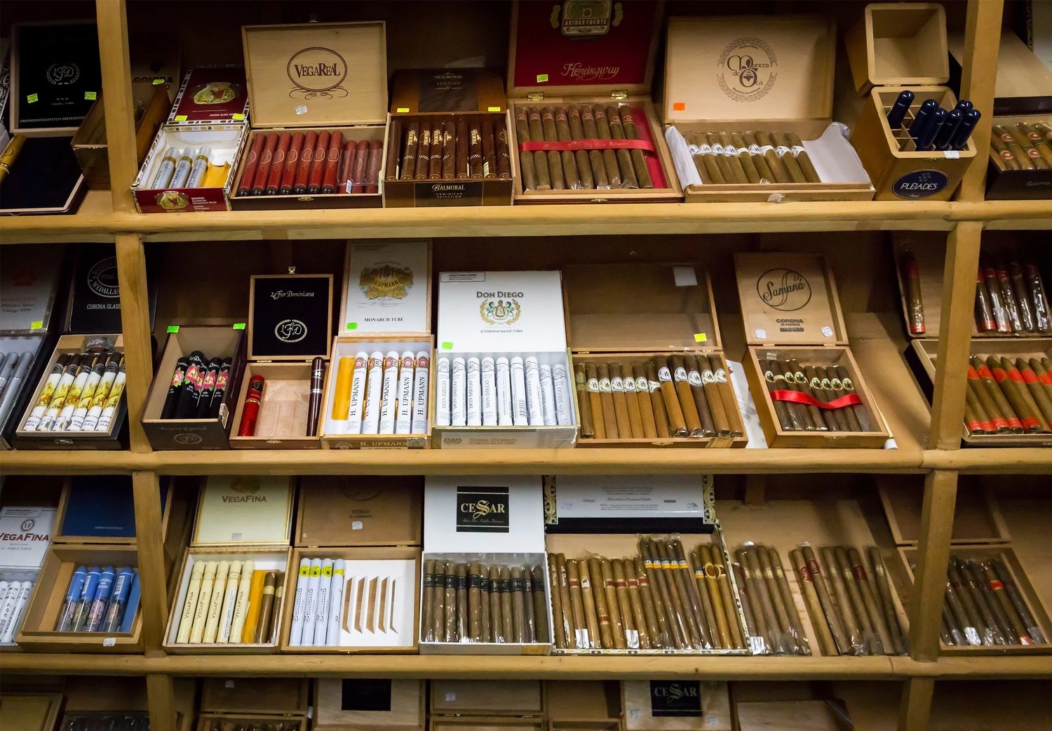 Shelves filled with premium cigar boxes and varieties at a shisha store in Tulsa, showcasing a diverse selection.