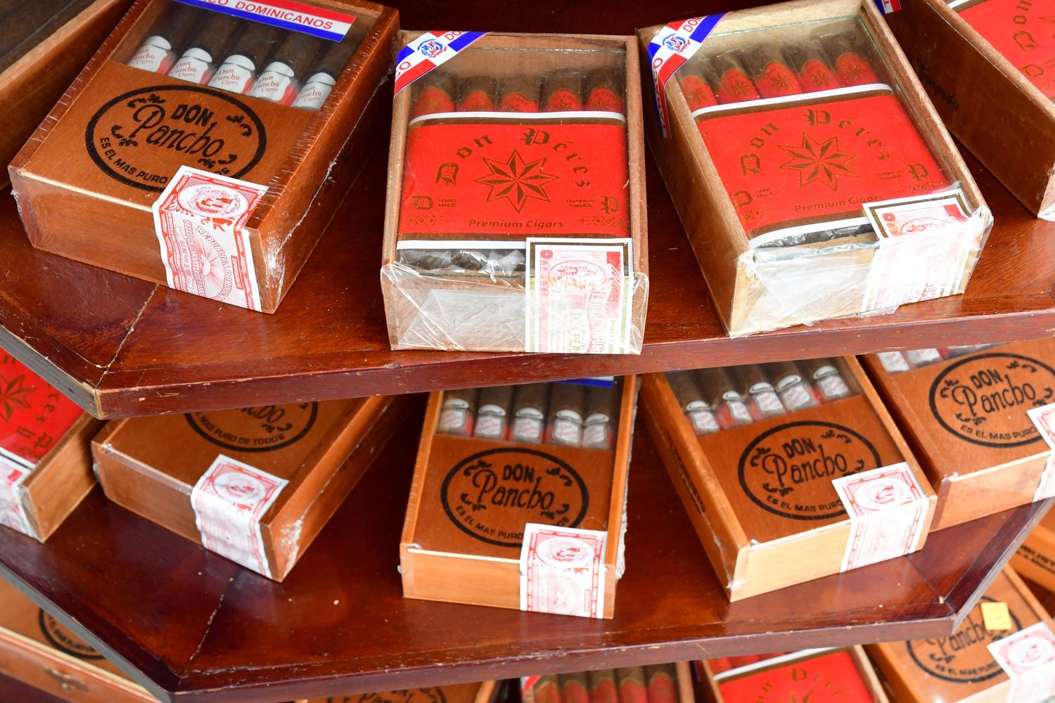 Premium Don Pancho cigars in wooden boxes displayed at a Tulsa cigar store, showcasing vibrant packaging.