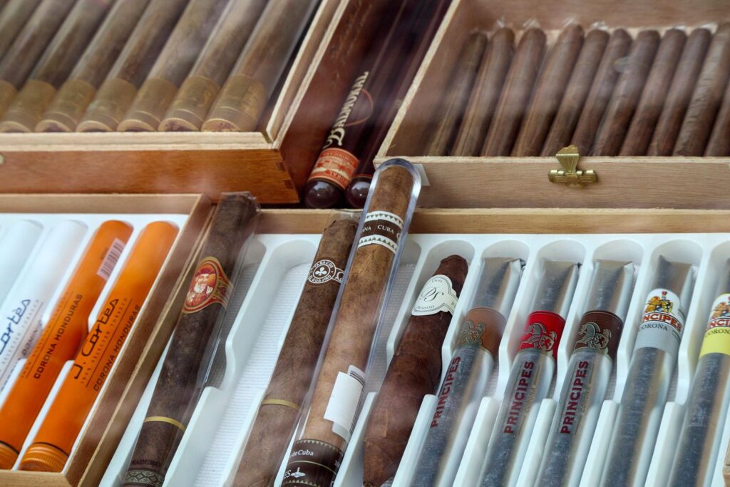 Premium cigars displayed in wooden boxes at a Tulsa cigar store, featuring various brands and packaging.