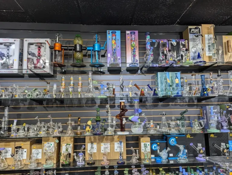 Row of artistic modern shisha pipes on a wooden counter display under warm lights at Shisha Store Tulsa.