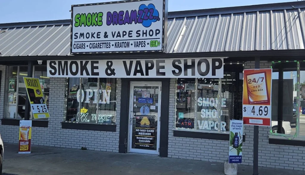Bright storefront of Smoke Dreamzzz Cigarette Shop Tulsa, offering cigars, vapes, kratom, and CBD with "Open" sign and deals.