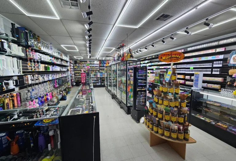 Spacious Cigarette Shop Tulsa interior with shelves of vapes, hookahs, and incense, brightly lit with a central display.
