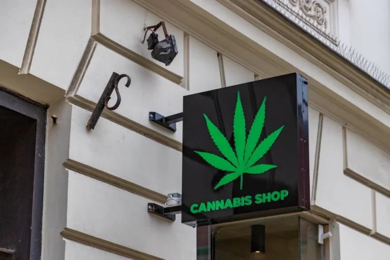 Exterior sign with a green cannabis leaf logo and "CANNABIS SHOP" text, similar products sold at Tobacco Shop Tulsa.