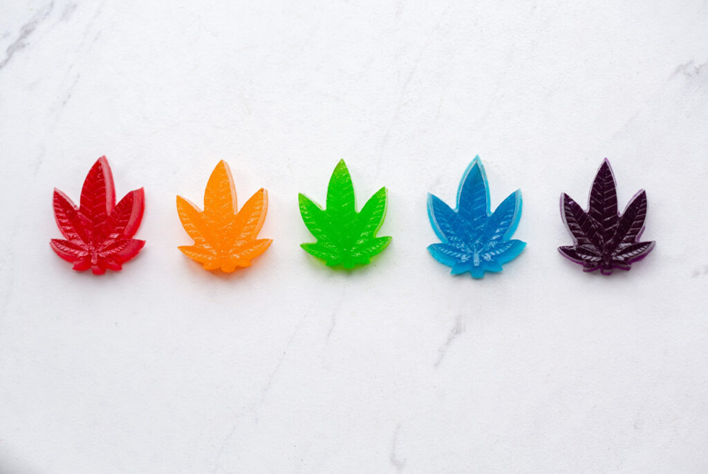 Brightly colored, leaf-shaped CBD gummies on display at a clean and modern cbd store tulsa location.