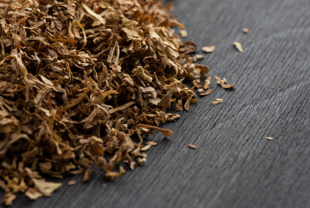 Close up of organic shredded natural tobacco on a dark wood surface sold at a professional tobacco shop Tulsa Oklahoma.