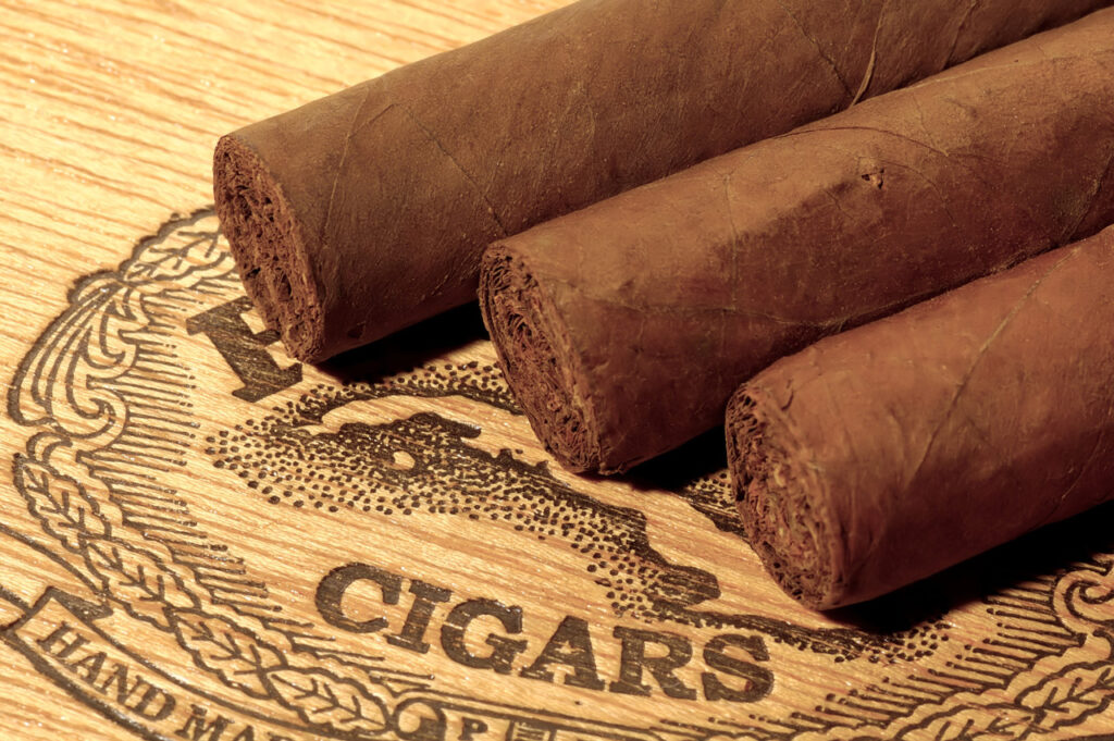 Premium hand-rolled cigars displayed on a branded wooden box at a luxury cigar store Tulsa for enthusiasts to enjoy.