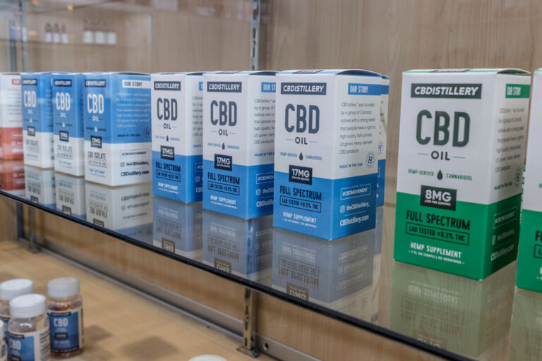 A retail display shelf inside a cbd shop Tulsa showing boxed CBDistillery brand full spectrum CBD oil tinctures.