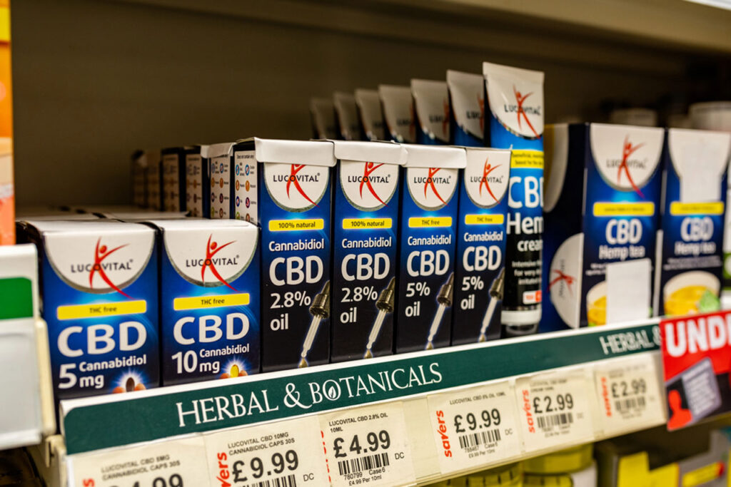 A retail pharmacy shelf section with boxed Lucovital brand CBD oils and teas for sale at a specialized cbd shop Tulsa.