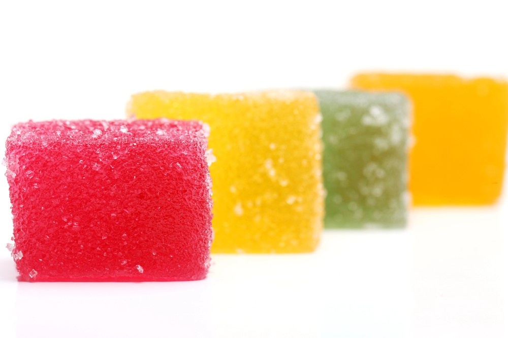 Four colorful, sugar-coated Delta 8 gummy squares from a reputable delta 8 shop tulsa.