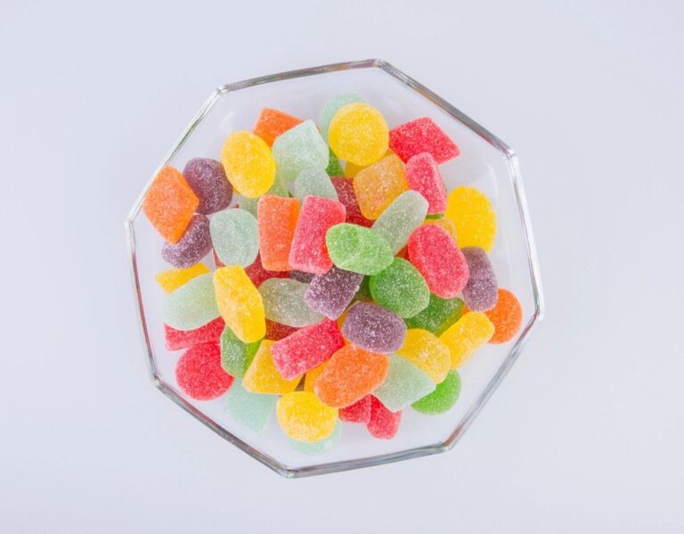 A glass bowl overflowing with assorted colorful Delta 8 gummies, from a leading delta 8 shop tulsa.
