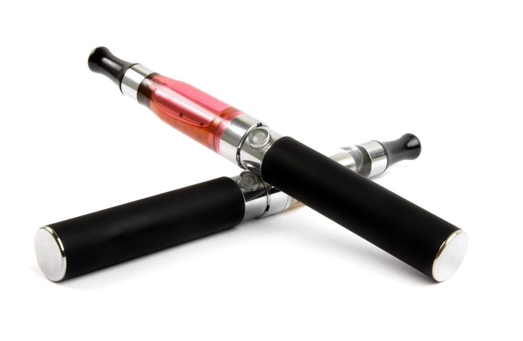 Two refillable e-cigarettes Tulsa vape pens with pink liquid tanks isolated on white for a clean commercial look.
