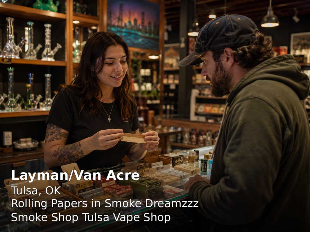 Friendly smoke shop clerk showing premium rolling papers Tulsa to a male customer inside Smoke Dreamzzz store.